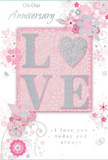 This anniversary card is shown as a romantic still life, the sort of keepsake one might display in a Richmond home alongside a vase of soft pink flowers. At its heart, the word LOVE emerges in large, raised letters brushed with sparkling glitter, the texture catching the light to create a gently shimmering focus. The surrounding palette of blush pink, creamy white, and silver lends an airy, luminous feel, similar to the soft tones chosen for anniversary arrangements delivered across Richmond's tree-lined streets. Radiating out from the central word, stylised flowers and flowing vines stretch across the card in delicate sweeps. Each bloom is drawn with fine, expressive lines, its petals gently shaded to suggest volume without heaviness, while the leaves curl and twist like the natural movement of stems in a hand-tied bouquet. Silver accents glint subtly along some petals and flourishes, echoing the gleam of a vase or the reflection of evening light on the Thames. Interlaced with the florals, an affectionate anniversary message appears in an elegant script, its curves and loops visually harmonising with the arcs of the vines. The script does not dominate; instead, it sits comfortably among the flowers, as if the words themselves were part of the arrangement. The overall impression is one of peaceful celebration and enduring affection-a card that feels both delicate and sincere. You can almost sense its weight in your hand, feel the raised glitter under your fingertips, and picture it resting beside a fresh bouquet chosen to honour another year of shared life in Richmond.